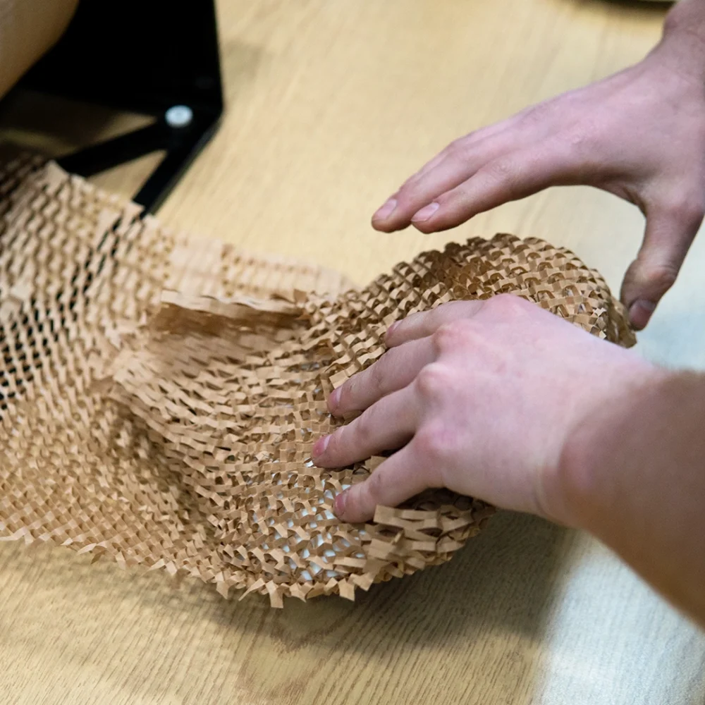 Hexcel paper being used to wrap around a china plate.