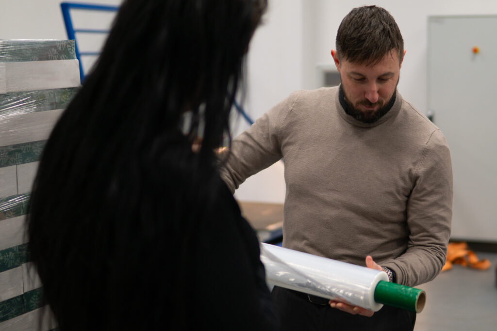 Close-up of a high-quality pallet wrap roll being inspected for long-term storage viability and material clarity.