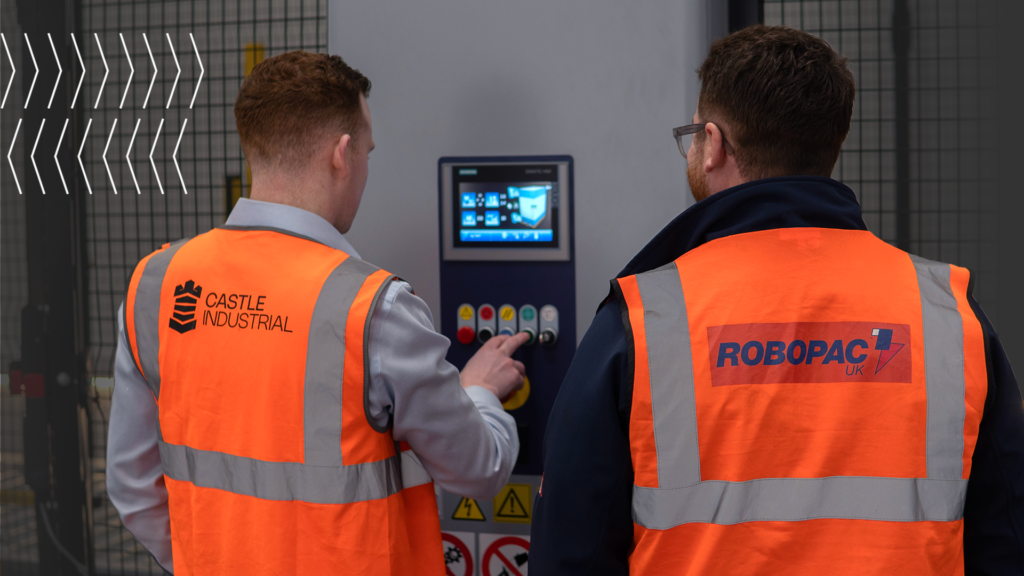 Two warehouse operatives selecting wrapping settings on a Robopac Technoplat's digital display