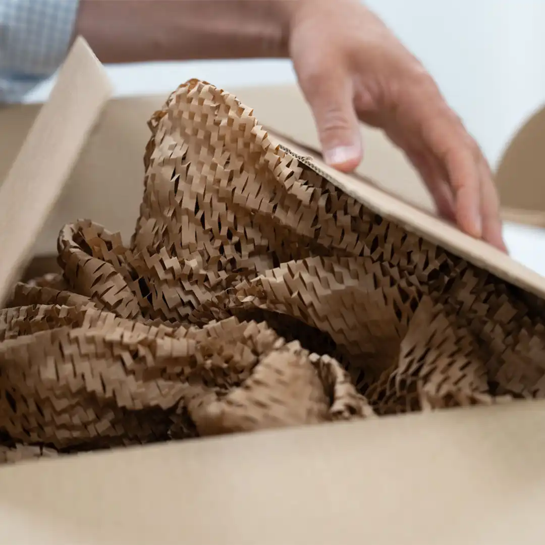 Hexafil Close Up Close up of a hand closing the lid of a cardboard box with Hexafil wrap inside