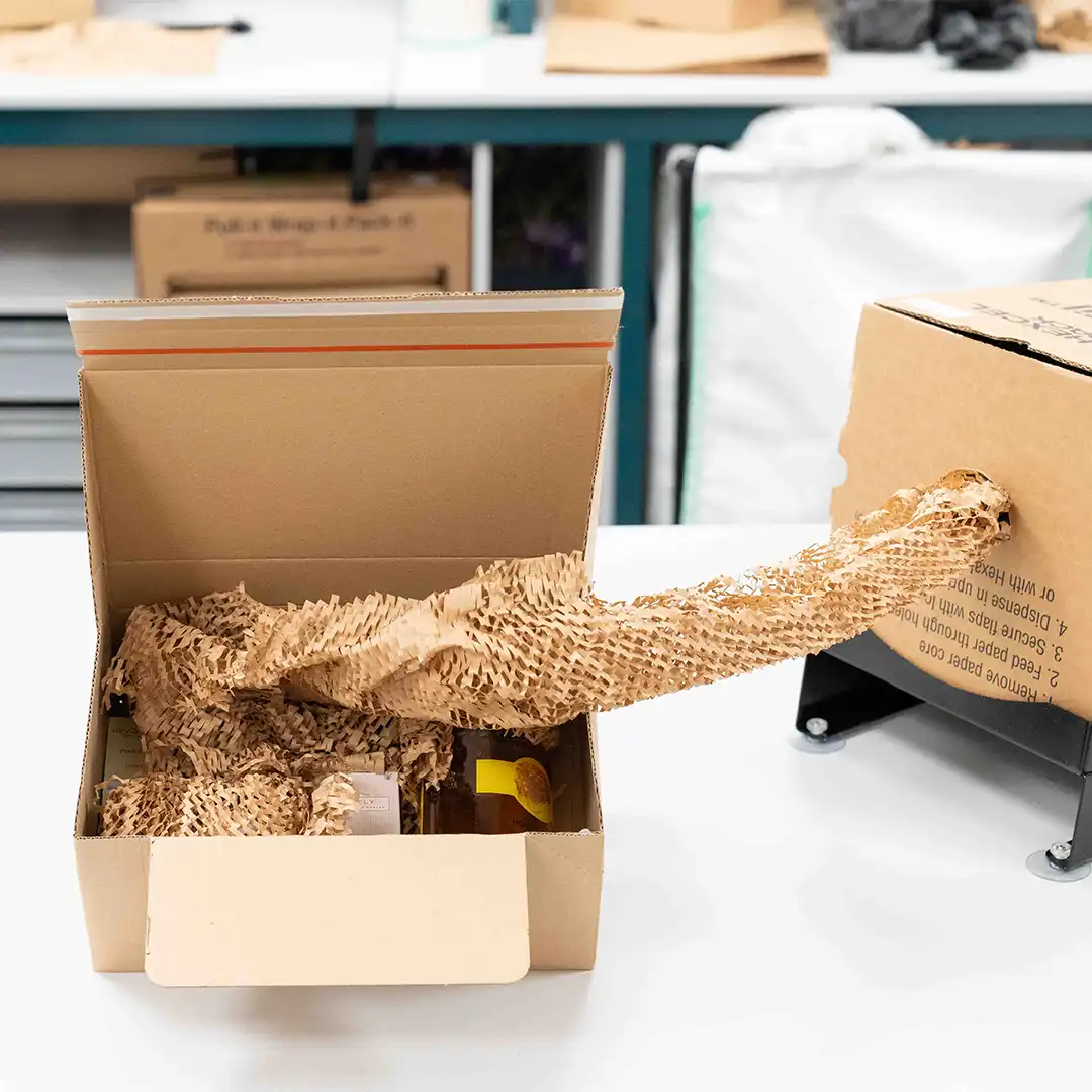 Hexafil Package Protection Hexafil coming out of dispenser and into cardboard box with fragile goods inside