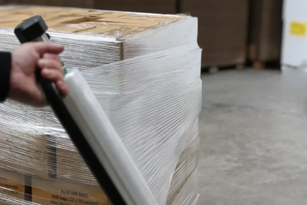 Wrapping a pallet using a hand dispenser